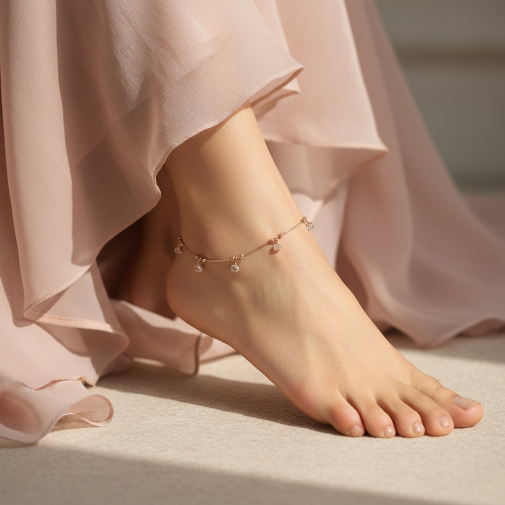 Gold anklet with crystals on a dark background, featuring the brand 'Saheli'.