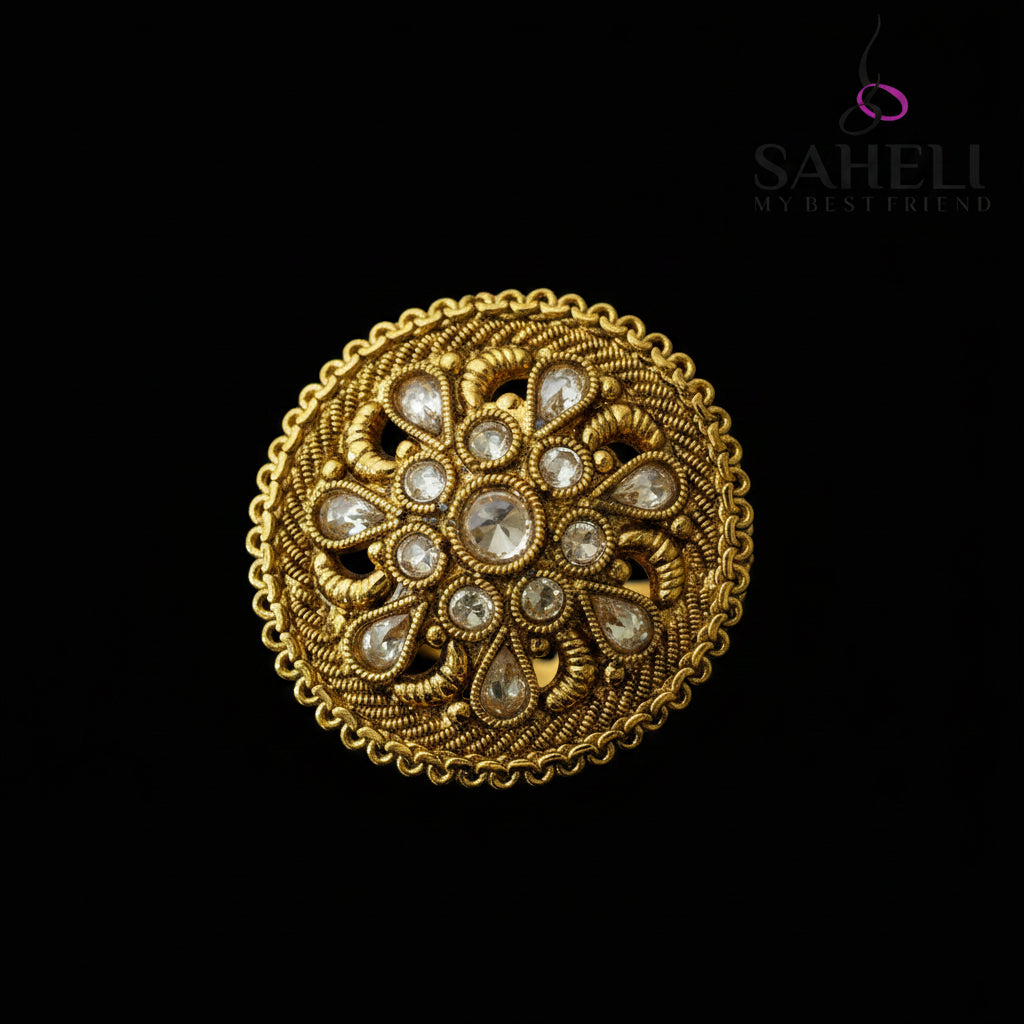 An ornate round gold-toned brooch or decorative pin with intricate filigree detailing and clear teardrop-shaped stones, displayed on a dark gray background with a 'SAHELL MY BEST FRIEND' watermark in the top right.
