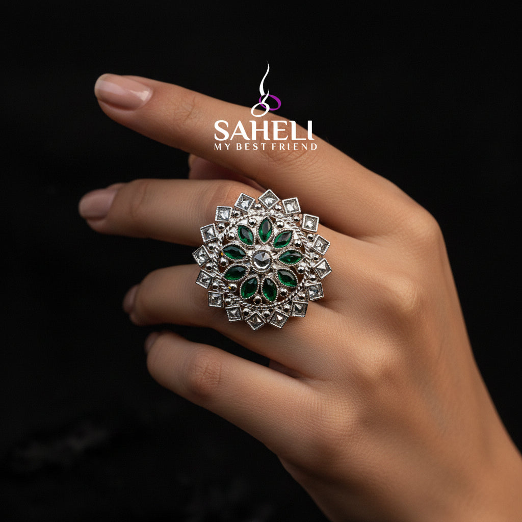 A large silver-toned floral ring with green stone accents is displayed on a black velvet hand against a dark background, with the brand name SAHELL MY BEST FRIEND printed above.