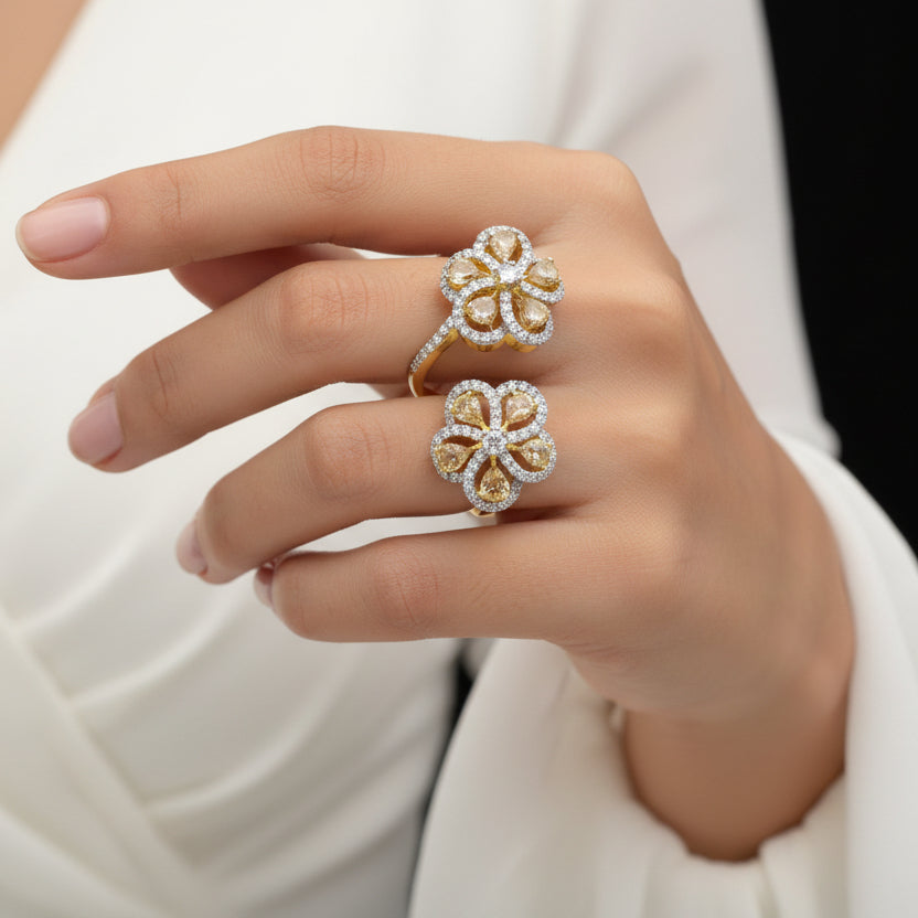 Gold and diamond earrings on a gray background with 'SAHELLI' branding.