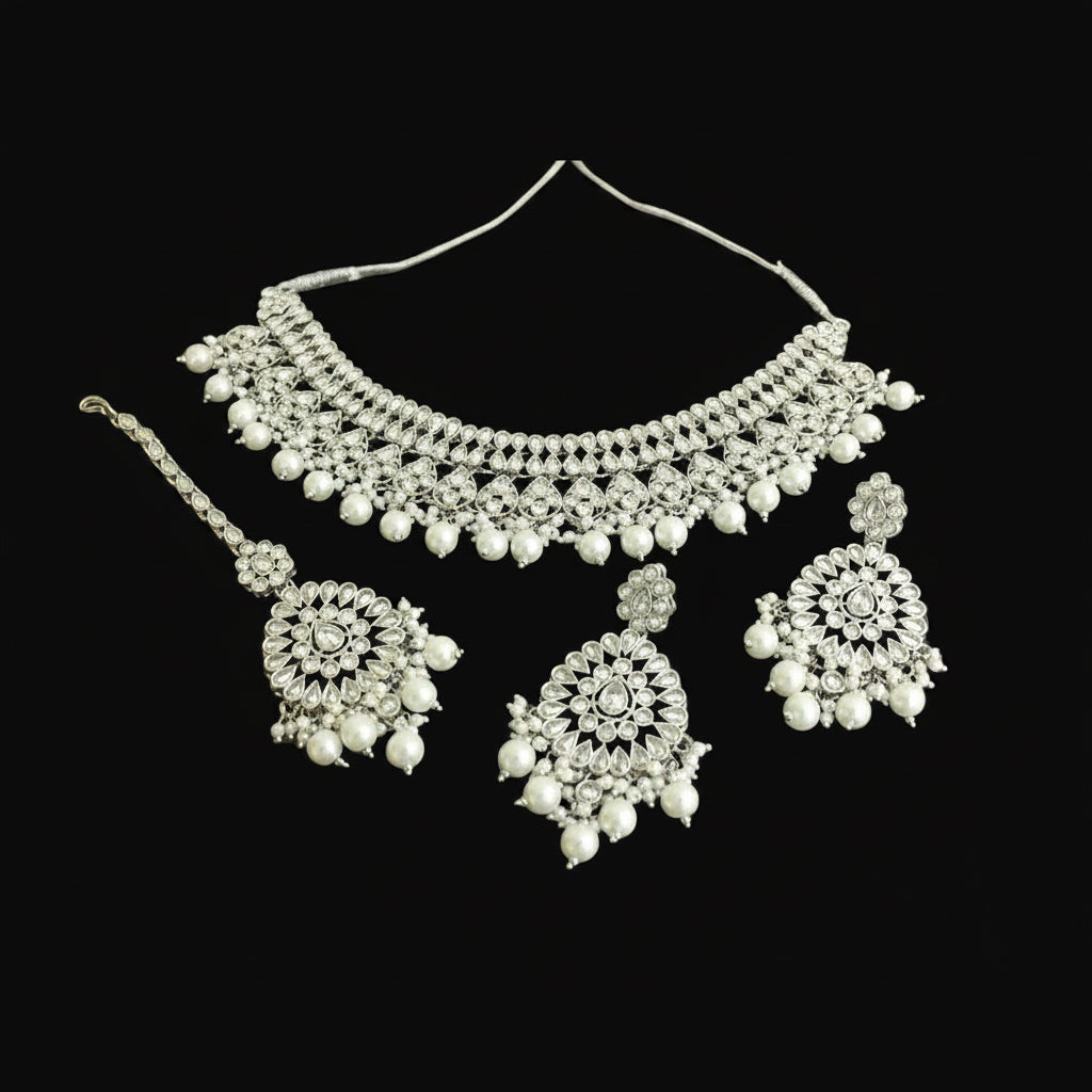 Silver necklace with matching earrings on a black background