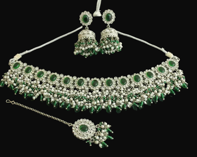 Jewelry set with necklace, earrings, and ring on a dark background