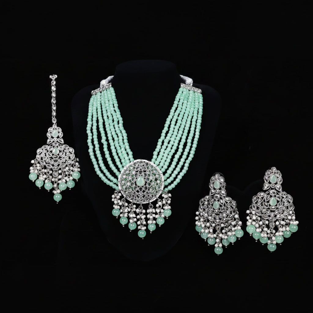 Jewelry set with necklace, earrings, and pendants on a black background with 'Saheli' branding.