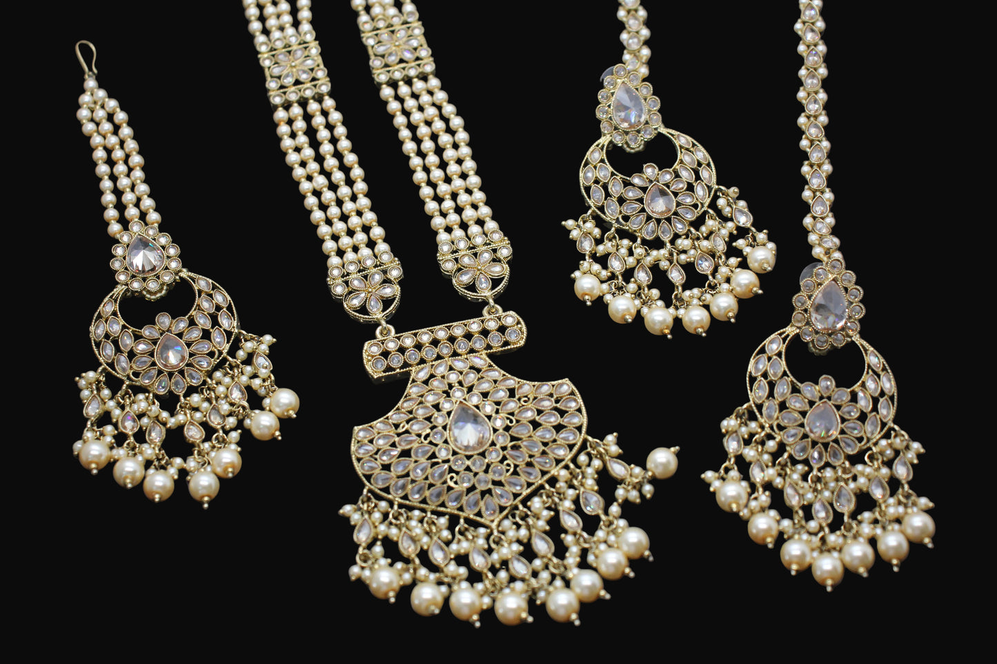 Gold necklace with pearl pendants on a dark background