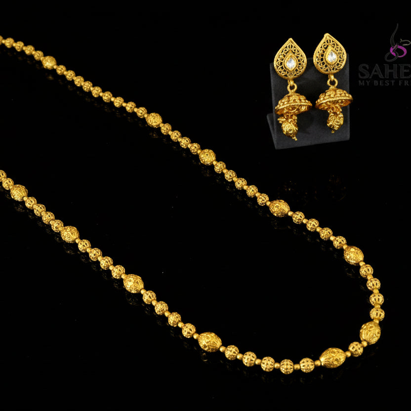 Gold necklace and earrings set with 'Saheli' branding on a gray background
