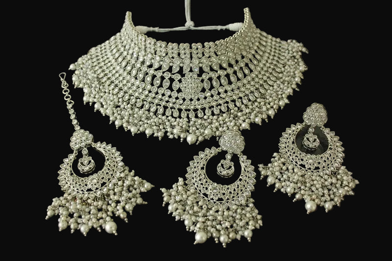 Silver necklace and earrings set on a dark background