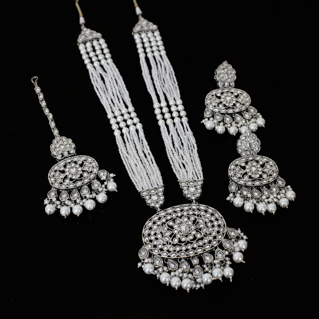 Silver jewelry set with necklace, earrings, and bangles on a black background