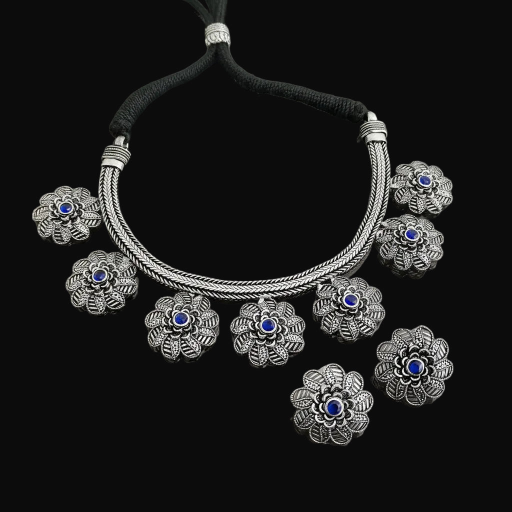 Silver bracelet with floral designs on a gray background, featuring the brand 'Saheli'.