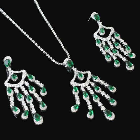 Jewelry set with necklace and earrings featuring green gemstones on a dark background