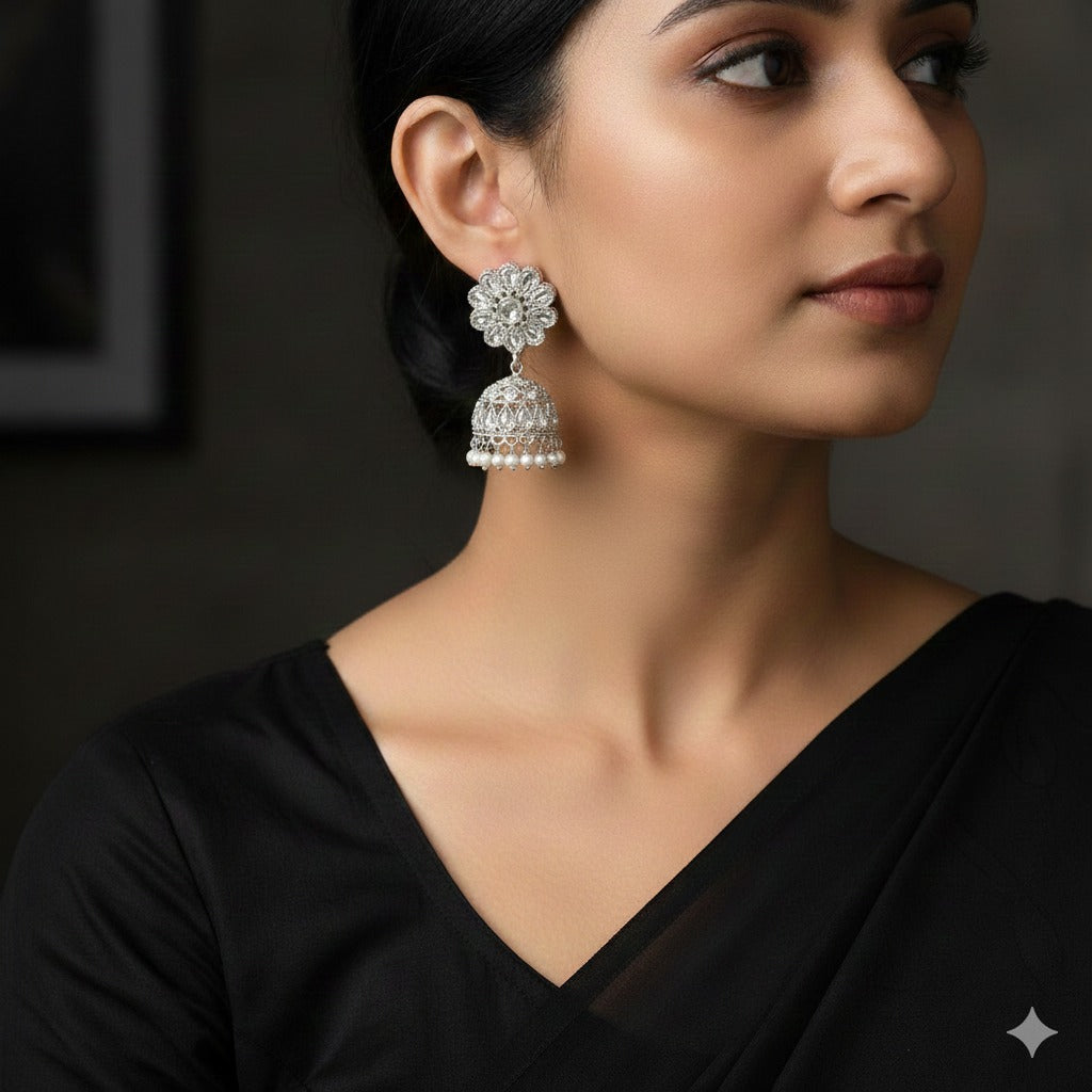 Woman wearing silver earrings with a dark background