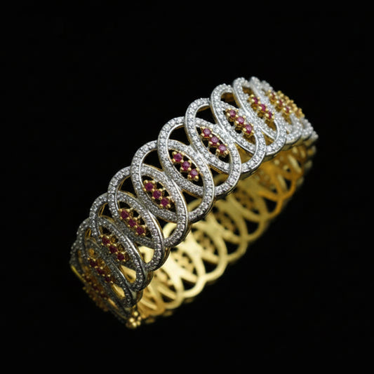 Gold and silver necklace with red stones on a black stand, branded 'Saheli'.