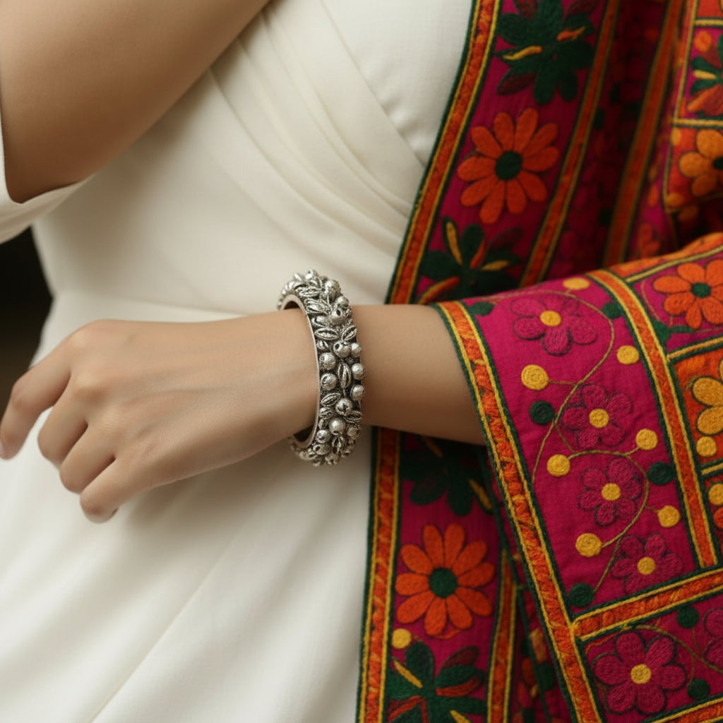 Silver ring with textured band on a dark background