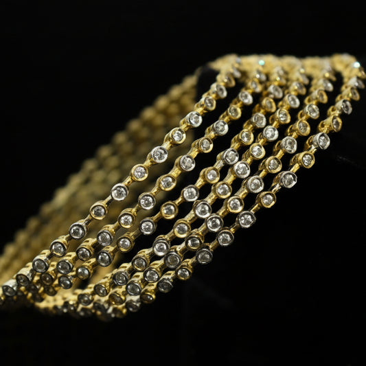 Gold bracelet with clear stones on a dark background, featuring the brand 'Saheli'.