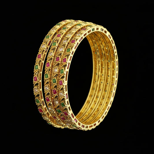 Gold bangles with gemstones on a gray background, featuring the brand 'SAHELI'.