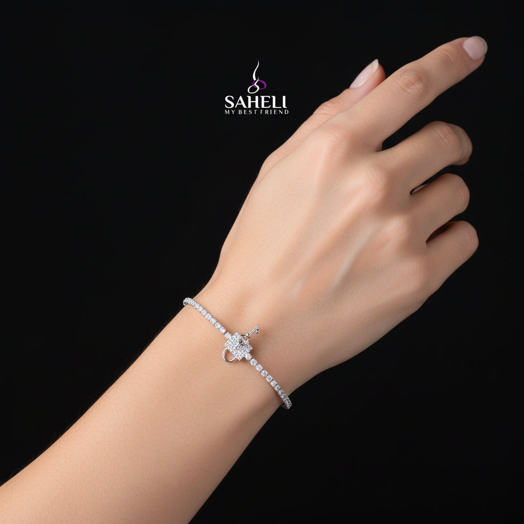 Silver bracelet with a clasp on a dark background, featuring the 'SAHELI' brand.