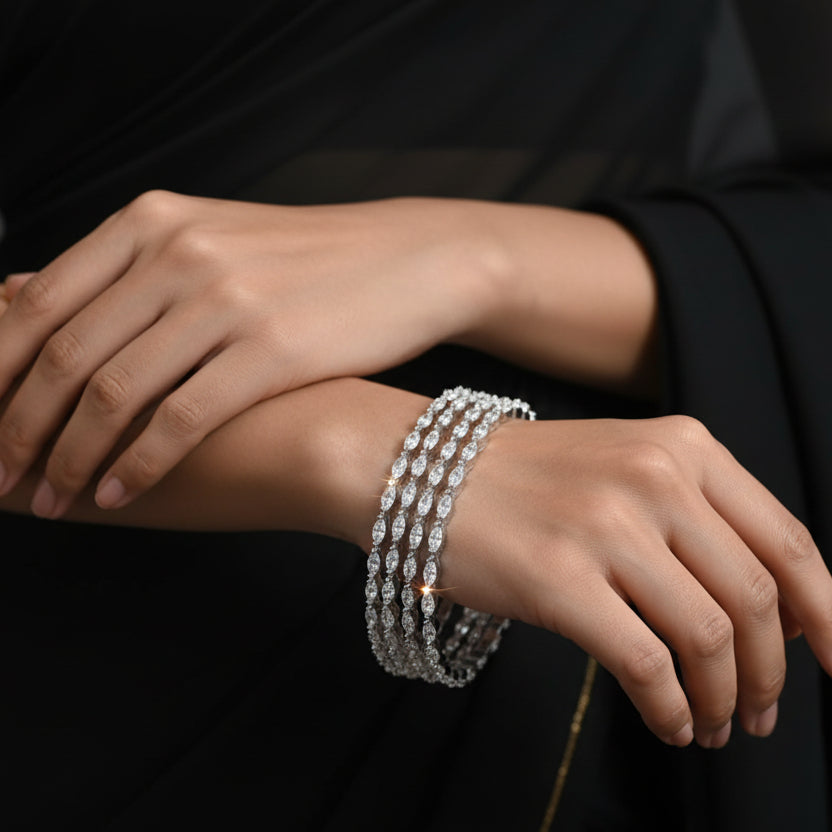 Set of diamond bracelets on a gray cushion against a dark background