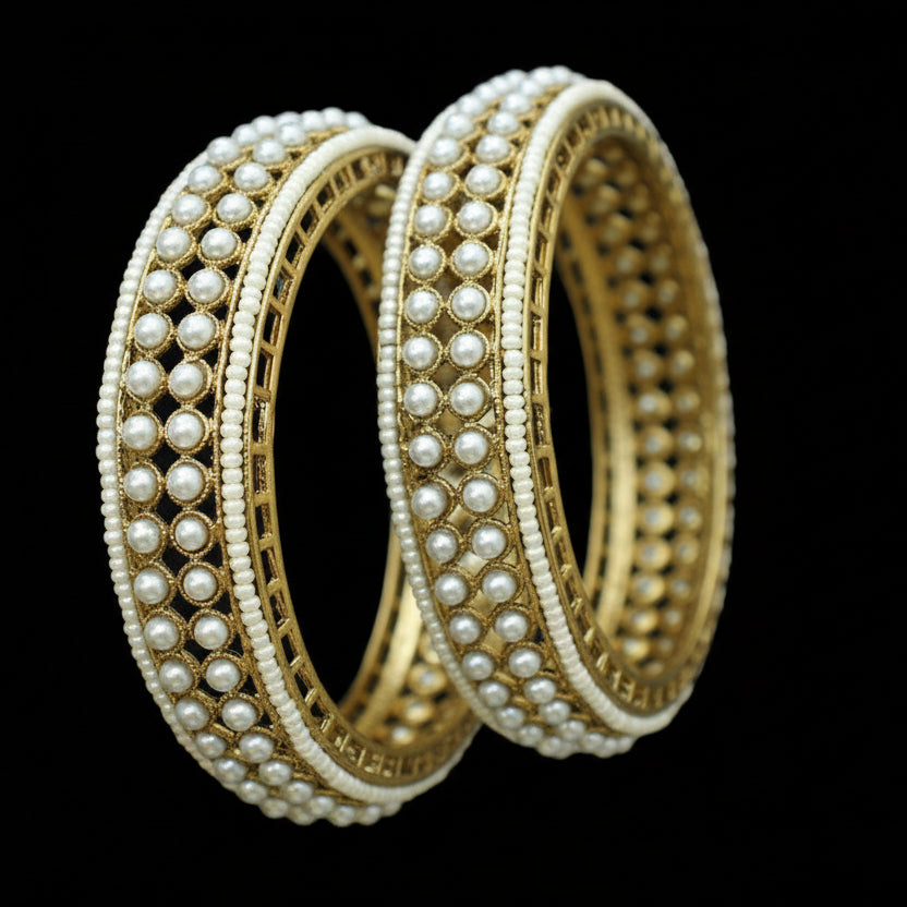 Gold and pearl bangles on a dark background with 'Saheli' branding.