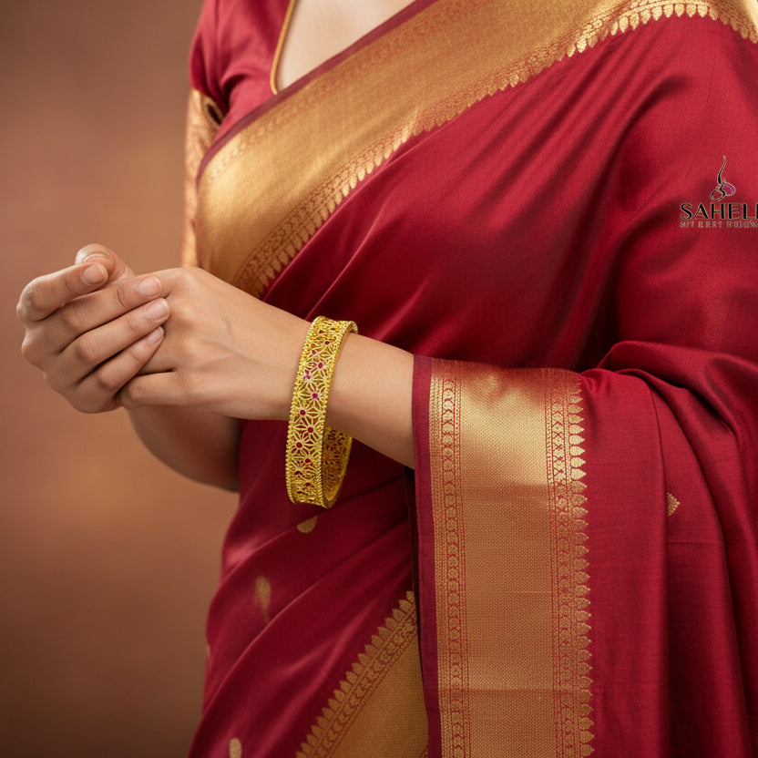 Gold bangles with intricate designs on a dark background