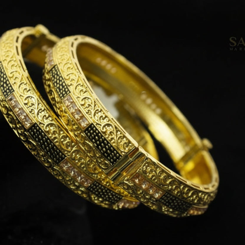 Gold bangles with intricate designs on a dark background, featuring the brand 'Saheli'.