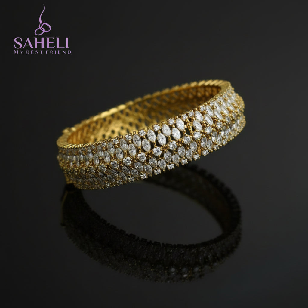 Gold bracelet with diamonds on a black background, featuring the brand 'Saheli'.