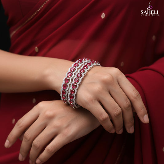 Two red gemstone bracelets on a dark background with 'SAHELI' branding.