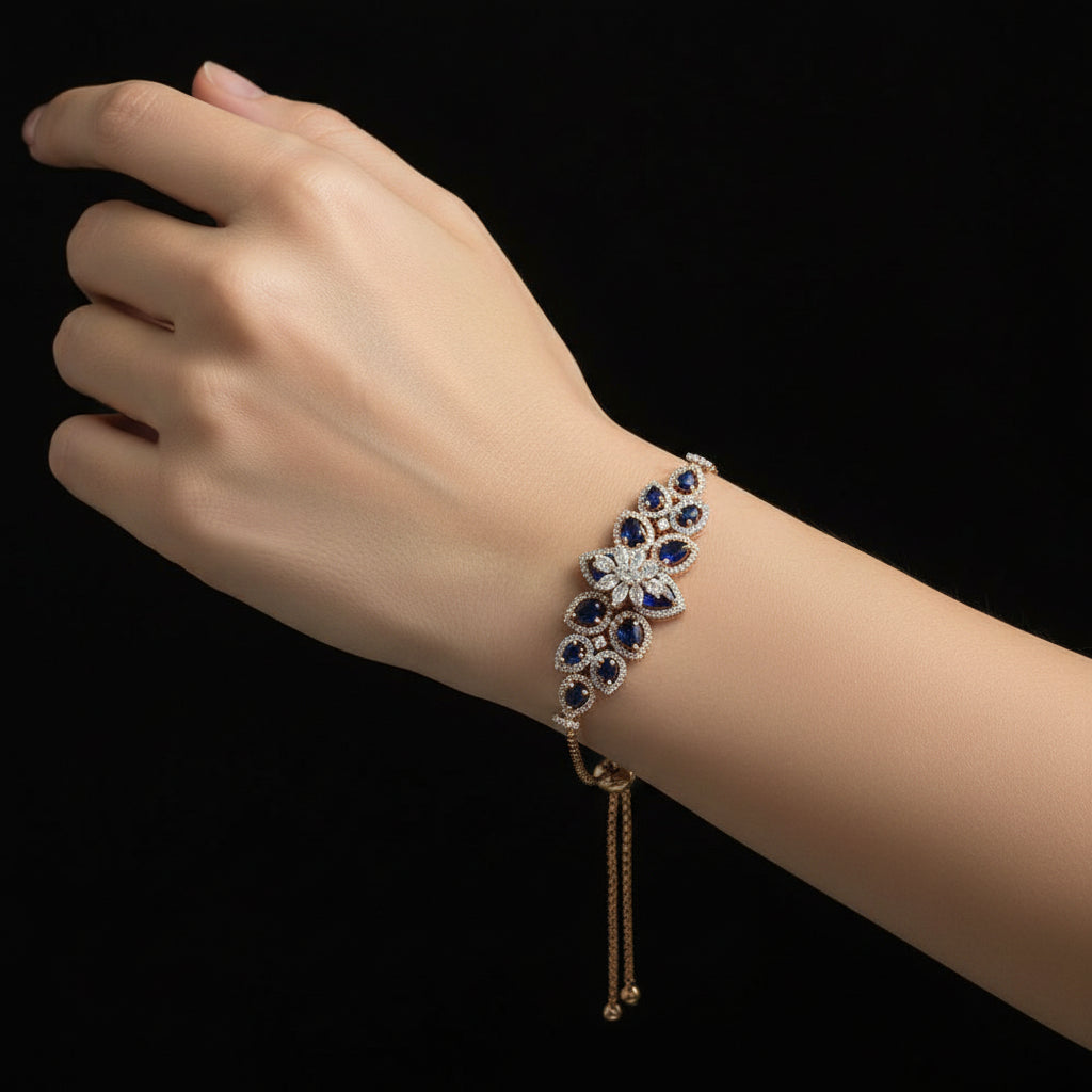 Gold necklace with diamond and blue gemstone pendant on a black background