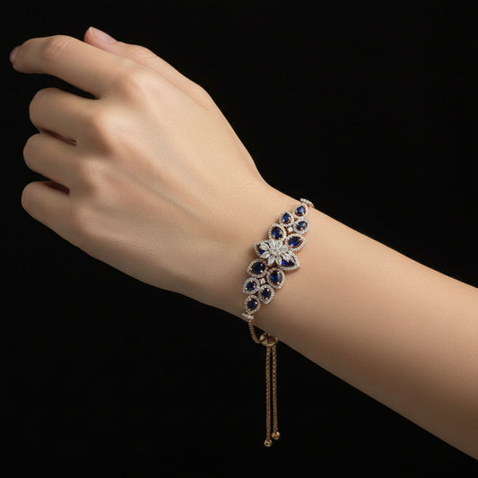 Gold necklace with diamond and blue gemstone pendant on a black background