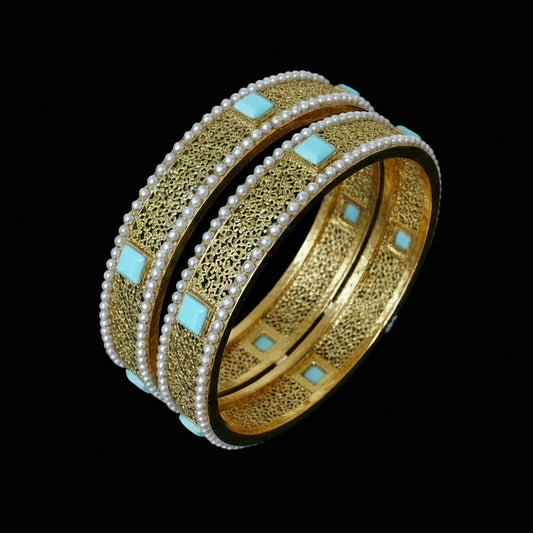 Gold bangles with turquoise stones on a dark background, branded 'Saheili'.