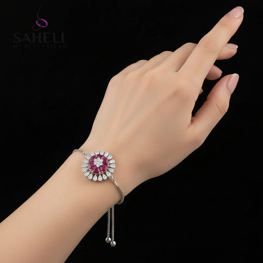 Silver bracelet with pink gemstone on a gray background, featuring the brand 'SAHELI'.