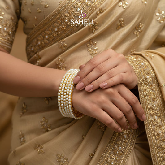 Pearl bracelet with gold accents on a black background, featuring the brand 'SAHELI'.