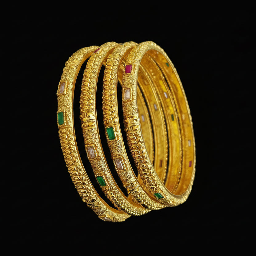 Gold bangles with embedded stones on a gray background, featuring the brand 'Saheli'.