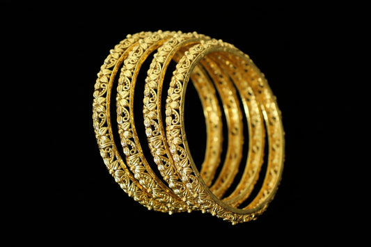 Gold bangles on a stand with 'SAHELI' branding.