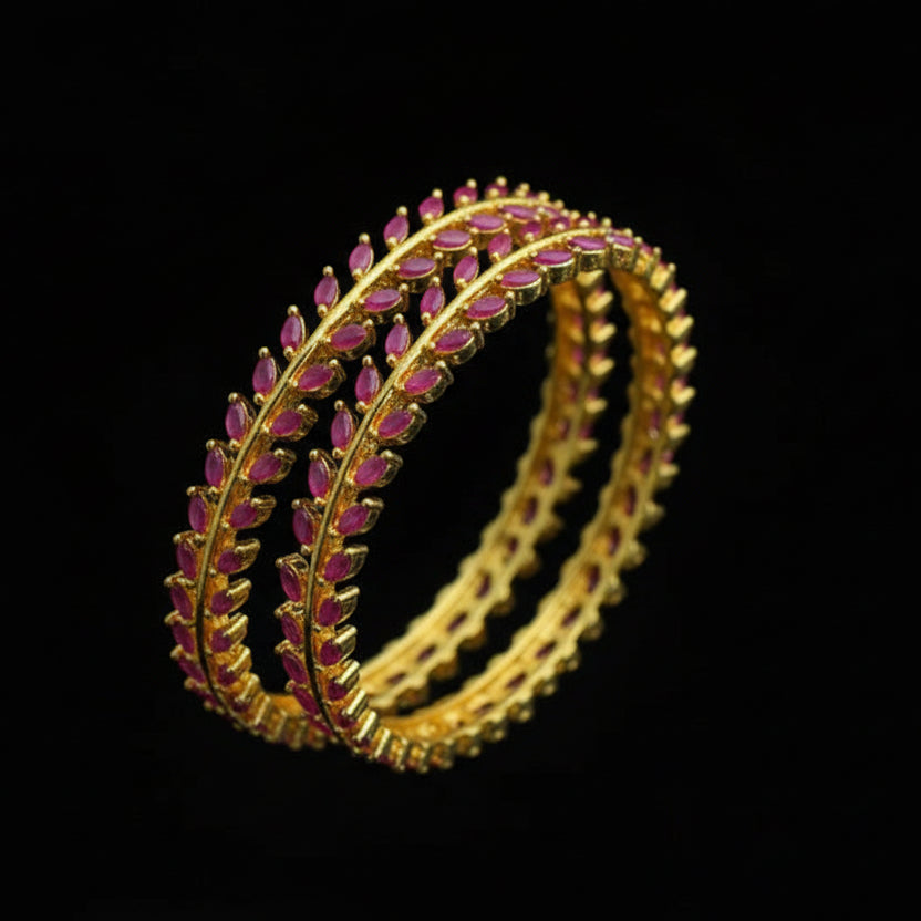Gold and pink bangles on a black fabric background with 'SAHELI' branding.