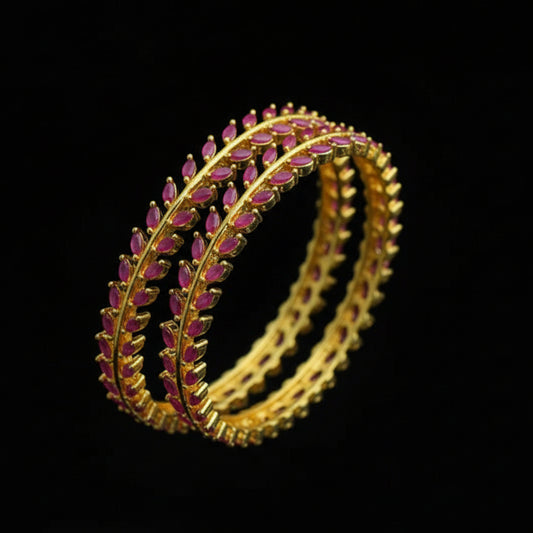 Gold and pink bangles on a black fabric background with 'SAHELI' branding.