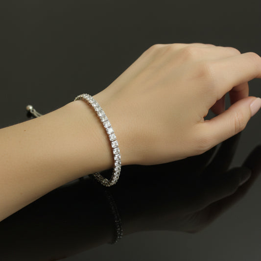 Silver bracelet with small stones on a dark background