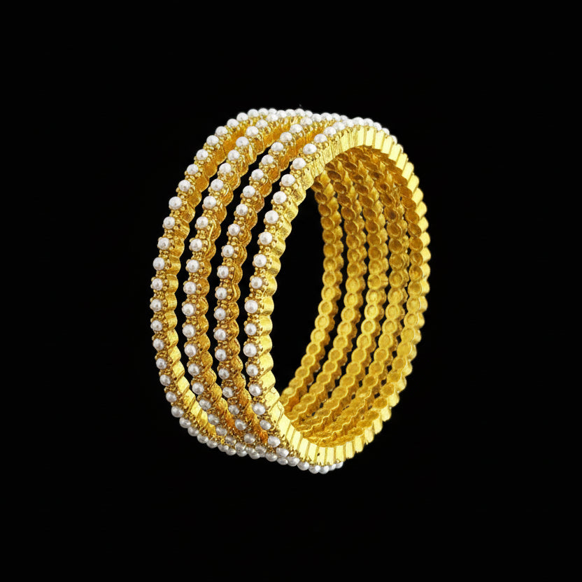 Set of gold and pearl bangles on a gray background with 'SAHELLI' branding.