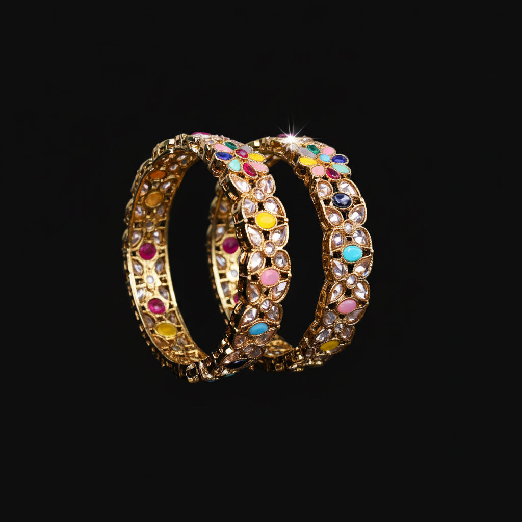 Pair of ornate bangles with colorful stones on a black background, branded 'Saheli'.