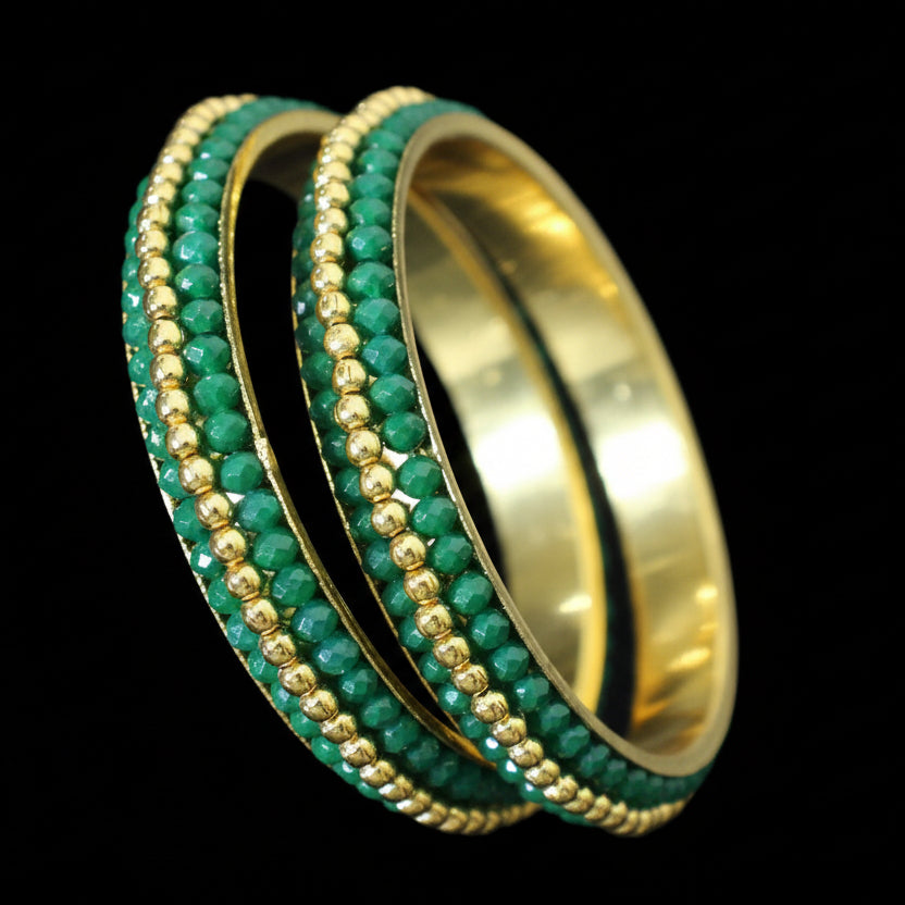 Gold and green bangles on a black stand with 'SAHELI' branding.