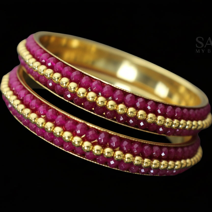 Gold and pink beaded bangles on a gray background with 'SAHELI' branding.