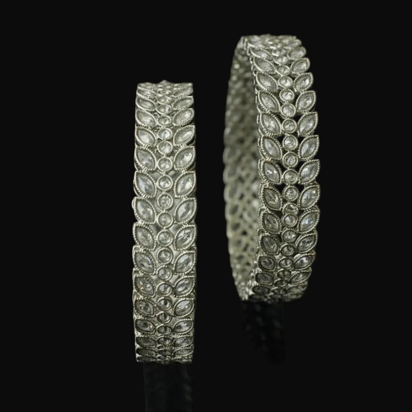 Two silver bracelet with gemstones on a dark background