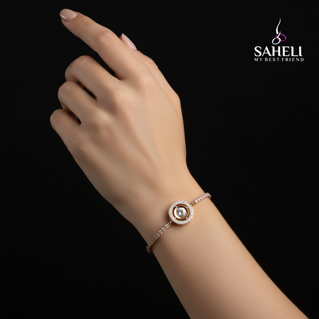Gold bracelet with a central gemstone on a black background, featuring the brand 'SAHELI'.
