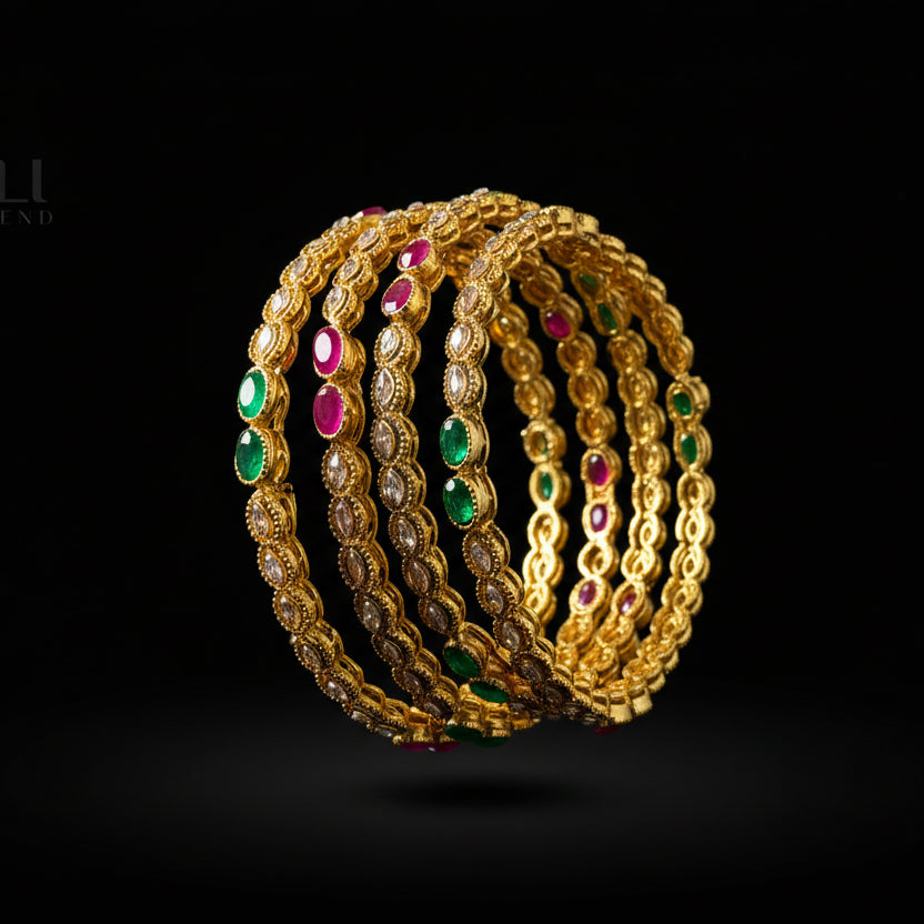 Gold bangles with colored stones on a black stand, branded 'SAHELI'.