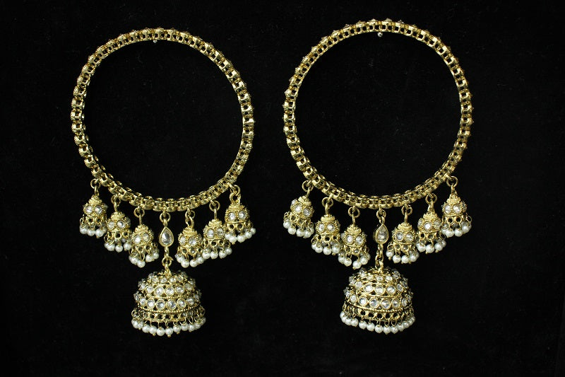 Pair of gold hoop earrings with dangling beads on a black background