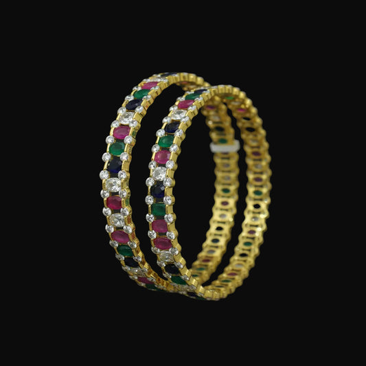 Jewelry bangles with gemstones on a black background, featuring the brand 'Saheli'.