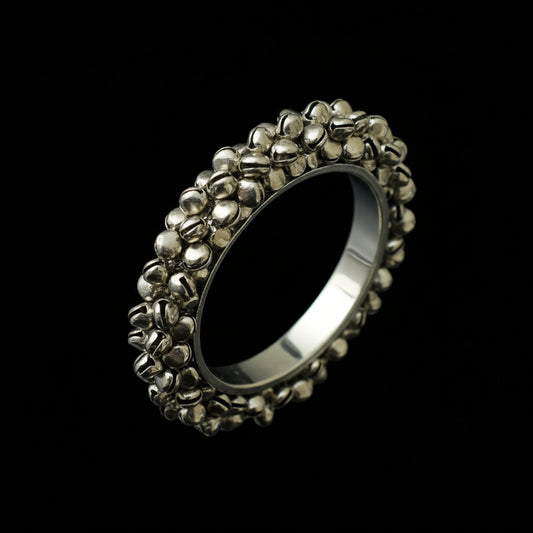 Silver ring with intricate design on a black background