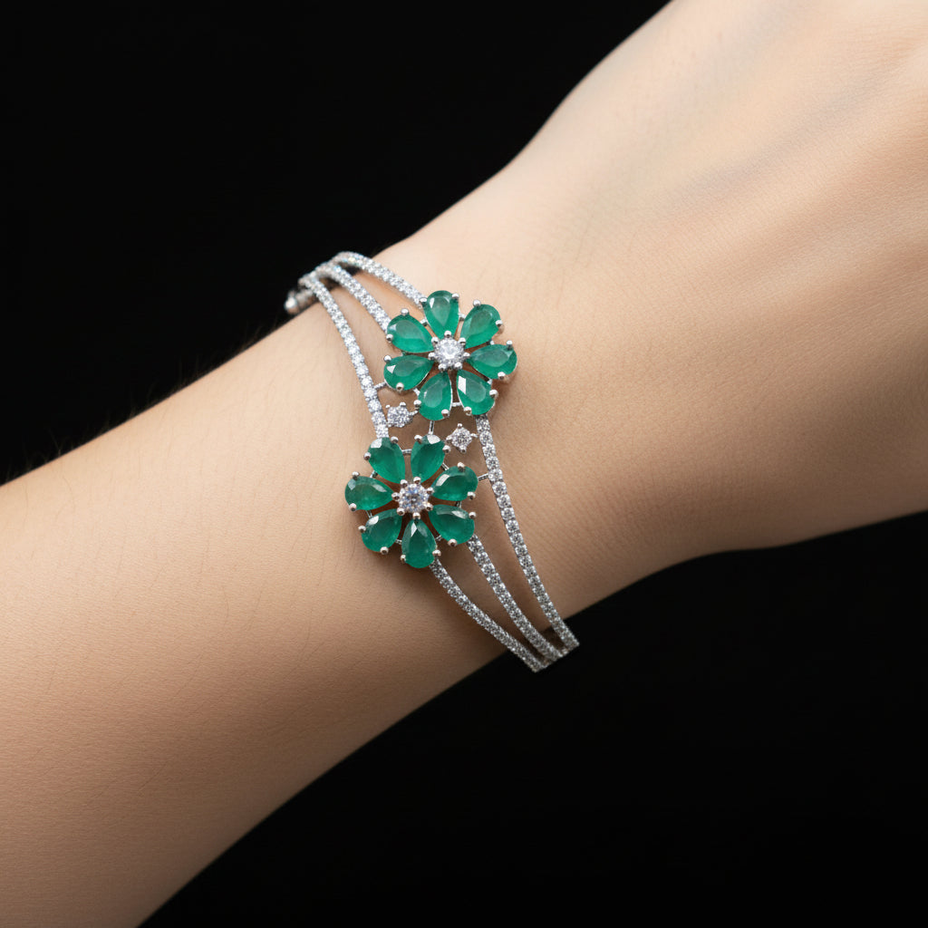 Silver bracelet with blue floral charms on a gray surface