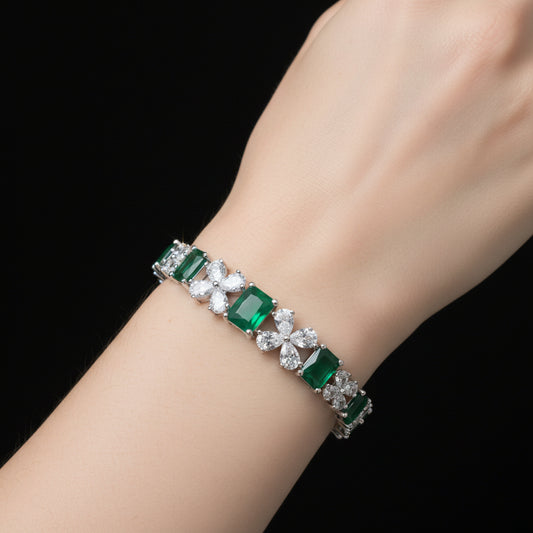 Bracelet with green and clear gemstones on a gray cushion