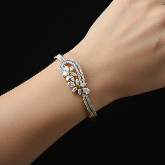 Delicate bracelet with floral design on a gray cushion against a dark background