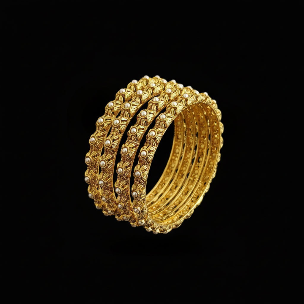Gold bangles on a gray stand with 'SAHELLI' branding.