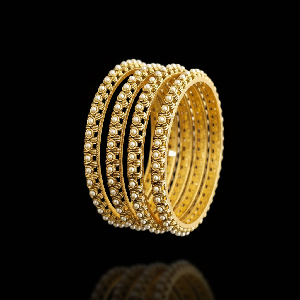 Gold bangles on a gray background with 'SAHELLI' branding.